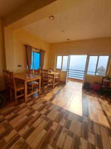 una sala da pranzo con tavolo, sedie e finestre di Himalayan Hidden Treasure a Pokhara