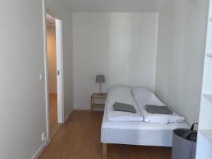a white bed in a room with a mirror at Tjuvholmen - ved Aker Brygge in Oslo