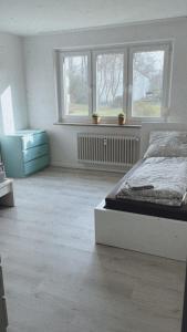 1 dormitorio blanco con 1 cama y 2 ventanas en Ferienwohnung Frieda, en Delmenhorst