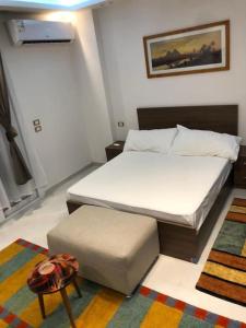 1 dormitorio con cama y reposapiés en SKY Management, en Hurghada