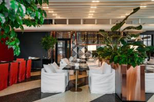 a dining room with a table and white chairs at Hotel Tbilisi Tower in Tbilisi City