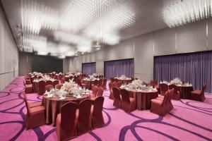 une grande salle de banquet avec des tables et des chaises dans l'établissement Crowne Plaza Dalian Xinghai, an IHG Hotel, à Dalian
