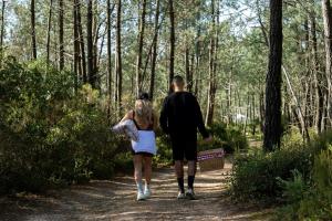 a man and a woman walking down a path in the woods at Hostel Pia do Urso in Batalha +35 photos