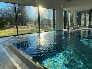 ein großer Pool in einem Haus mit Fenstern in der Unterkunft Koenigs Appartement mit Pool in Schluchsee