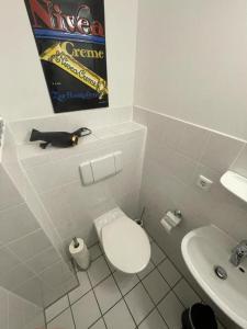 a white bathroom with a toilet and a sink at Air Apartments 9 in Bremen +4 photos