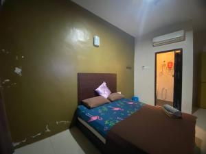 een slaapkamer met een bed met een telefoon erop bij TGL Aparthotel Tanjung Lumpur in Kuantan