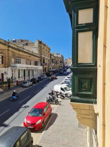 una macchina rossa parcheggiata sul lato di una strada cittadina di District a Victoria