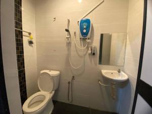 een badkamer met een douche, een toilet en een wastafel bij TGL Aparthotel Tanjung Lumpur in Kuantan