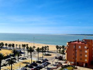 a view of a beach with cars parked in a parking lot at Playa Doñana 2 in Sanlúcar de Barrameda