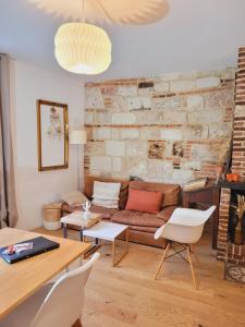 ein Wohnzimmer mit einer Couch und einer Ziegelwand in der Unterkunft -Parking privé -La BATISSE -Coeur historique - La Clef de Honfleur in Honfleur