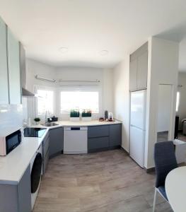a kitchen with white counters and a white refrigerator at Playa Doñana 2 in Sanlúcar de Barrameda