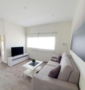 a living room with a couch and a tv at Playa Doñana 2 in Sanlúcar de Barrameda