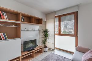 een woonkamer met een televisie en een raam bij Padova Palestro Pastel Apartment in Padua