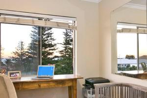 a laptop sitting on a desk in a room with a window at Spacious beach apartment, great sea views in Perth