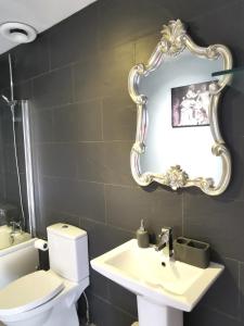 a bathroom with a toilet and a sink and a mirror at Victoriana Apartment, Central - Boutique in Stratford-upon-Avon