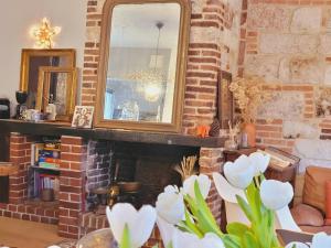 ein Wohnzimmer mit einem gemauerten Kamin und einem Spiegel in der Unterkunft -Parking privé -La BATISSE -Coeur historique - La Clef de Honfleur in Honfleur