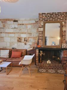 翁弗勒爾的住宿－-La Batisse -Parking privé -Coeur historique - La Clef de Honfleur，带沙发和壁炉的客厅