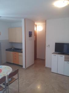 a living room with a table and a kitchen at Apartments Lončar in Novalja