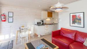 a living room with a red couch and a kitchen at Topcamp Bie - Grimstad in Grimstad