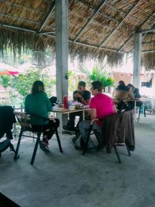 Ninh Binh Bungalow Homestay في نينه بينه: مجموعة من الناس يجلسون على الطاولات في المطعم
