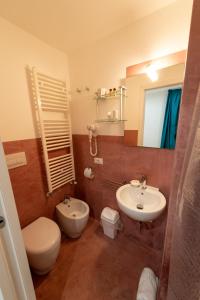 Un baño con inodoro, lavabo y espejo. en Claire, en Gallipoli