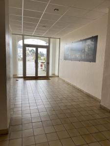 an empty room with a tile floor and a large window at L améthystes in Crozon