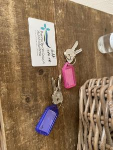 three keys on a table with a card and a basket at L améthystes in Crozon