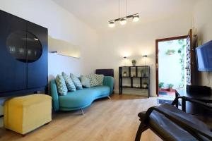 a living room with a blue couch and a tv at Kinahouse in Córdoba