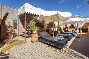 un patio con sofás y sombrillas en Dar Sohane, en Marrakech