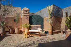 a patio with a chair and potted plants at Dar Sohane in Marrakech