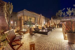 una fila de sillas y sombrillas en un patio por la noche en Dar Sohane, en Marrakech