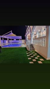 a house with a green lawn in front of it at Smart Chalet:سمارت شالية in Salalah