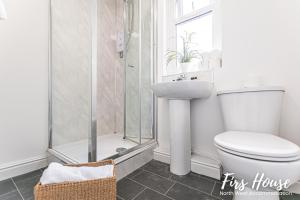 a bathroom with a toilet and a shower and a sink at Firs Serviced Accommodation in Leigh
