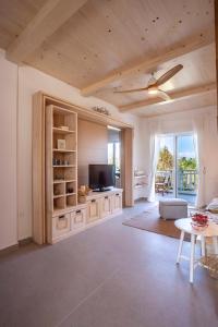 a living room with a television and a table at Calypso beach front apartment in Hanioti +48 photos