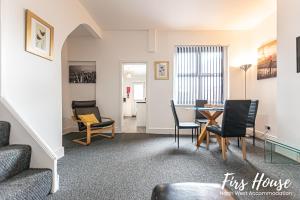 a living room with a table and chairs at Firs Serviced Accommodation in Leigh