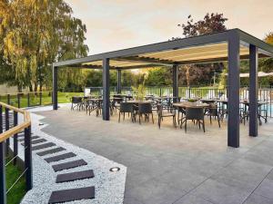 einen Pavillon mit Tischen und Stühlen auf einer Terrasse in der Unterkunft Novotel Roissy Saint Witz in Saint-Witz