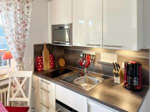 eine Küche mit Spüle und Mikrowelle in der Unterkunft Haus Diana *Ferienwohnung Wattenmeer* in Wittdün