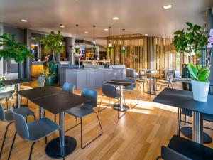 a restaurant with tables and chairs and a bar at Hotel Ibis Firenze Prato Est in Campi Bisenzio