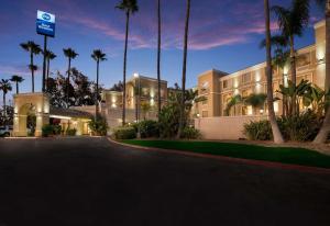 een groot gebouw met palmbomen ervoor bij Best Western Escondido Hotel in Escondido
