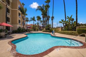 a swimming pool at a resort with palm trees at Best Western Escondido Hotel in Escondido