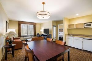 a living room with a dining table and a kitchen at Best Western Escondido Hotel in Escondido