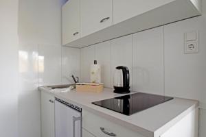 a kitchen with white cabinets and a black appliance at Air Apartments 10 in Bremen +4 photos