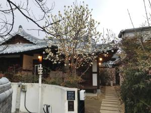 ein Haus mit einem Baum mit weißen Blumen darauf in der Unterkunft Sarangroo in Jeonju