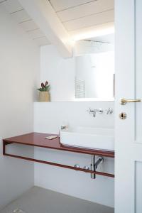 W łazience znajduje się umywalka i lustro. w obiekcie Casa Kiko Pecetto w mieście Pecetto