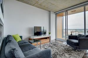a living room with a couch and a tv at Les Immeubles Charlevoix - Le 760-431 in Quebec City