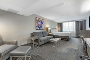 Habitación de hotel con sofá y cama en Best Western Premier Rockville Hotel & Suites, en Rockville