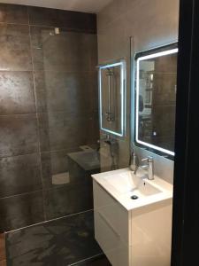 a bathroom with a sink and a mirror and a shower at Mimosa Residenza in St. Julianʼs +14 photos
