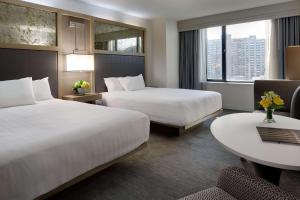 a hotel room with two beds and a table at Hyatt Regency Boston in Boston