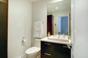 a bathroom with a sink and a toilet and a mirror at Les Immeubles Charlevoix - Le 760-431 in Quebec City +14 photos