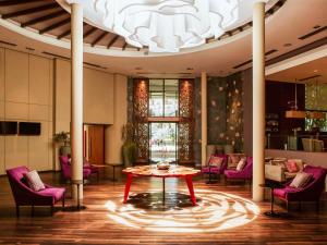 een kamer met een tafel en stoelen en een kroonluchter bij Mercure Iguazu Hotel Iru in Puerto Iguazú